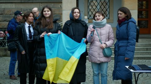 PRAGUE, CZECH REPUBLIC, FEBRUARY 24, 2022: Demonstration Ukrainian women girls sings national anthem hymn people against Russian military attack war Russia on Ukraine crowd protest Ukrainians
