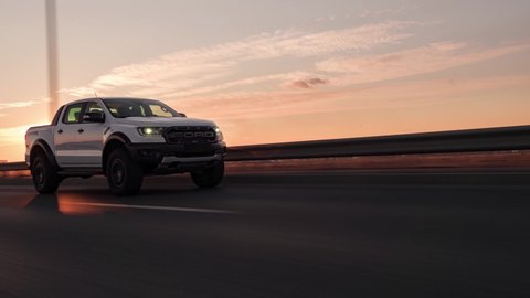 Berlin, Germany- 01.20.2022: Rolling shots of a Ford Ranger Raptor SUV pickup truck car driving on highway at sunset, close up view