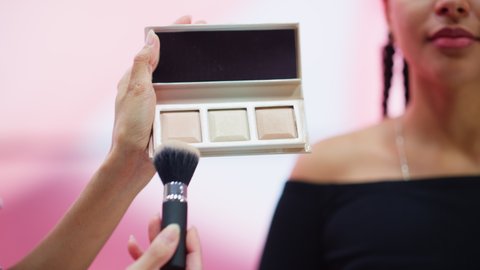 Professional Beauty Expert uses Blush Contour Palette on a Portrait of Beautiful Black Model, Advertising Best Beauty Products, Cosmetics. Concept of Online Blog Vlog or TV Advertising. Close-up