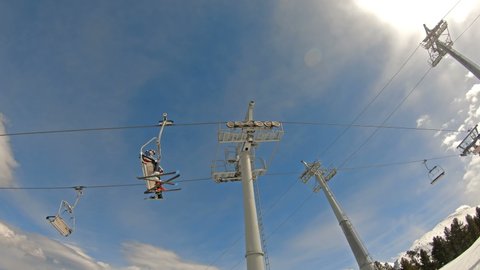 Bansko, Bulgaria - circa Feb, 2022: Skiers go on the lift on mountain in Bansko, Bulgaria, slow motion