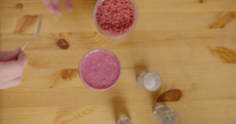 Close up footage of woman putting goji berries on a smoothie.