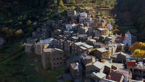 DRONE AERIAL FOOTAGE: The picturesque little schist village of Piodão clings to a steeply terraced mountainside deep within the foothills of the Serra de Açor range in central Portugal.