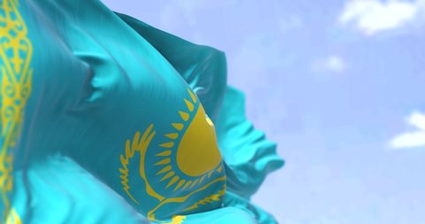 Detail of the national flag of Kazakhstan waving in the wind on a clear day. Kazakhstan is a transcontinental country located mainly in Central Asia, and partly in Eastern Europe. Selective focus.