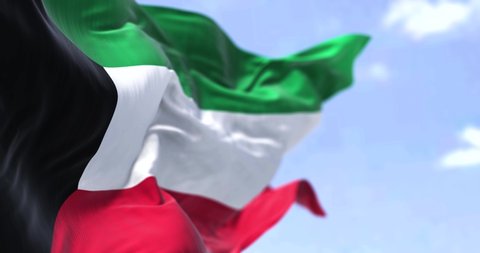 Detail of the national flag of Kuwait waving in the wind on a clear day. Kuwait is a country in Western Asia. Selective focus. Seamless loop in slow motion