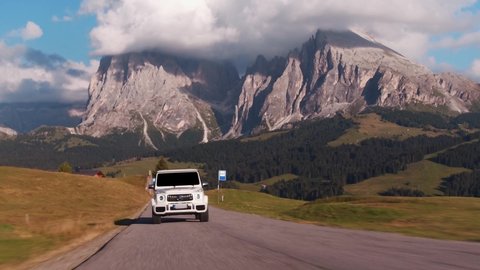 Alpe di Siusi, Italy- 09.10.2021: Rolling shots of Mercedes Benz G Class SUV luxury sport car driving on a mountain highway in Dolomites Alps, Italy 