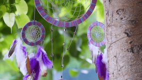 Close up of dream catcher on background of tree leaves with vibrant tone. Hand made. Dreamcatcher flowing in wind - Powered by Shutterstock - Get 15% off with code: PIKWIZARD15
