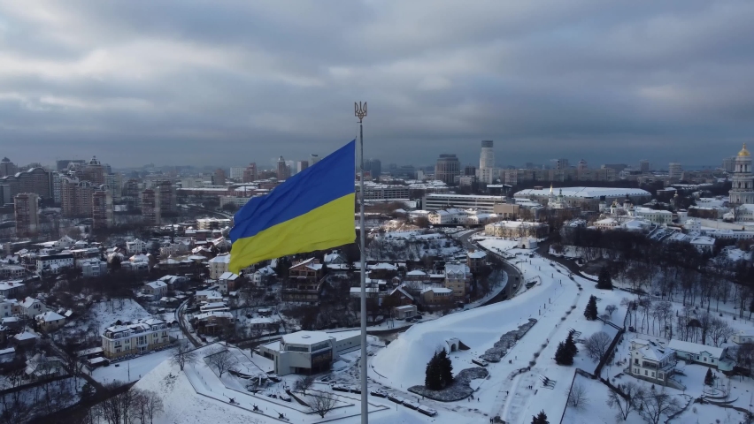 Ukrainian flag. Winter Kyiv (Kiev) panorama. The biggest flag in Ukraine. Ukraine simbol.