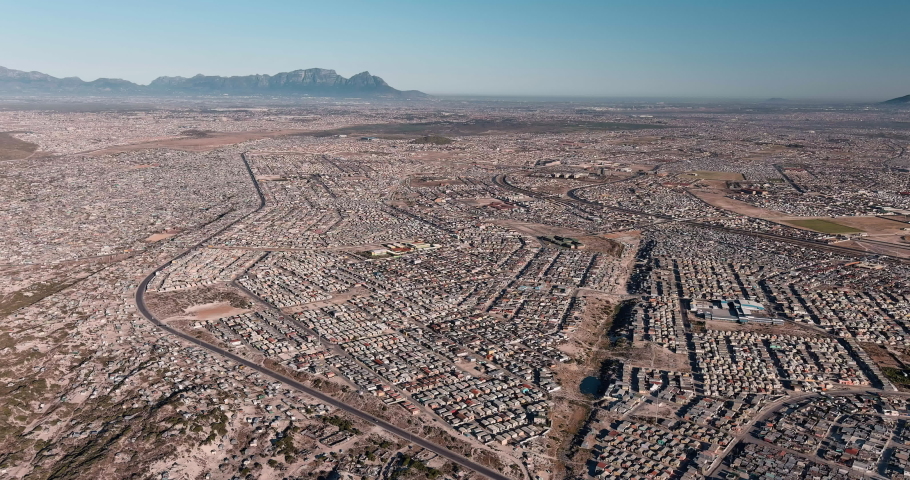 Poverty. Inequality. High aerial fly over view of the densely populated Khayelitsha township on the Cape Flats, Cape Town, South Africa