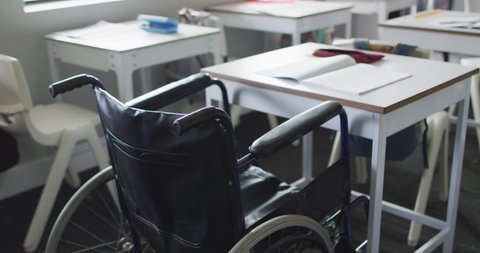 Video of empty wheelchair standing at desk in classroom. disability, primary school education and learning.