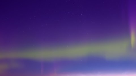 Aurora polaris lights, northern lines dancing in horizon, clear night sky with stars, time lapse winter clouds.