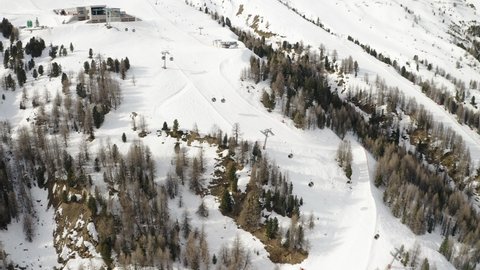 Livigno, Italy - February 21, 2022: Aerial view of Livigno ski resort in Lombardy, Italy. Chairlifts, ski lifts, gondola cabin are moving and skiers skiing over scenery panorama. 4k video footage 