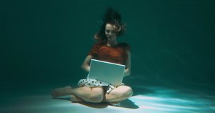 FUN WEB CONFERENCE CONCEPT Young beautiful freelancer woman talks to friends using laptop webcam underwater slow motion.
