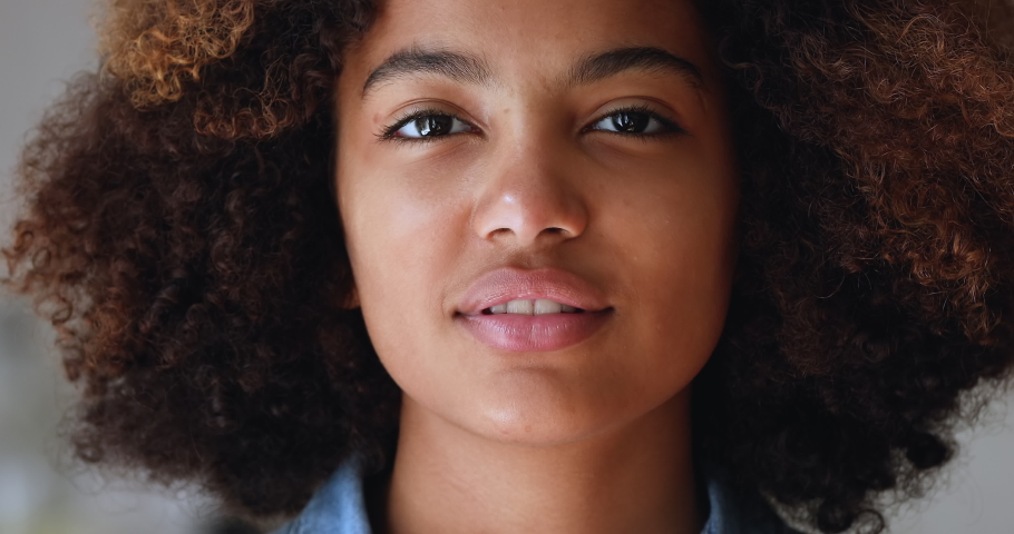 Close up cropped front face view beautiful African teenage girl with natural afro curly hairs having wide toothy smile looks at camera. Advertises dental clinic services, gen Z person portrait concept Royalty-Free Stock Footage #1088101125