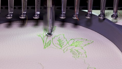 Machine embroidery on beige leather with green thread. Embroidery design with flowers up close. 4k video
