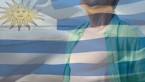 Animation of flag of uruguay over senior caucasian man relaxing with eyes closed on beach. senior lifestyle, retirement and holiday concept digitally generated video.
