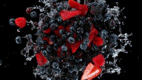 Super slow motion shot of rotating exploded berries fruit with splashing water on black at 1000fps. - Powered by Shutterstock - Get 15% off with code: PIKWIZARD15