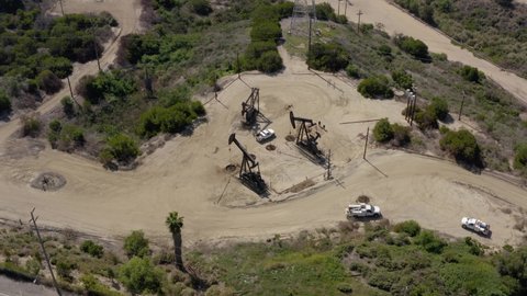 Oil rigs working in field at daytime. Oil pump jack on the factory.   Aerial view oil refinery factory. Aerial view of Oil Pumpjack. Industry equipment.