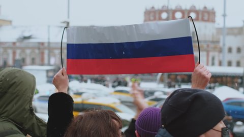 Protests in defense of Alexey Navalny. Protesters standing on streets of city with Russian national banner, flag. Support of protest struggle. Fight for democratic rights together.