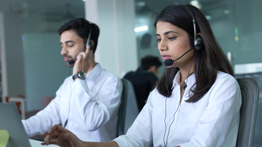 Call Center Office Portrait of Friends Indian Female IT Customer Support Specialist Working on Computer.Asian Business Entrepreneur Using Headset to Talk with Client via Online Video Conference Call. Royalty-Free Stock Footage #1088116267