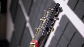 Strings, Vulture, Body of a Blue Acoustic-Electric Guitar Close up. The guitar is in a music studio, in-room with soundproofing on the walls. Front view. Professional modern musical instrument. 4K.