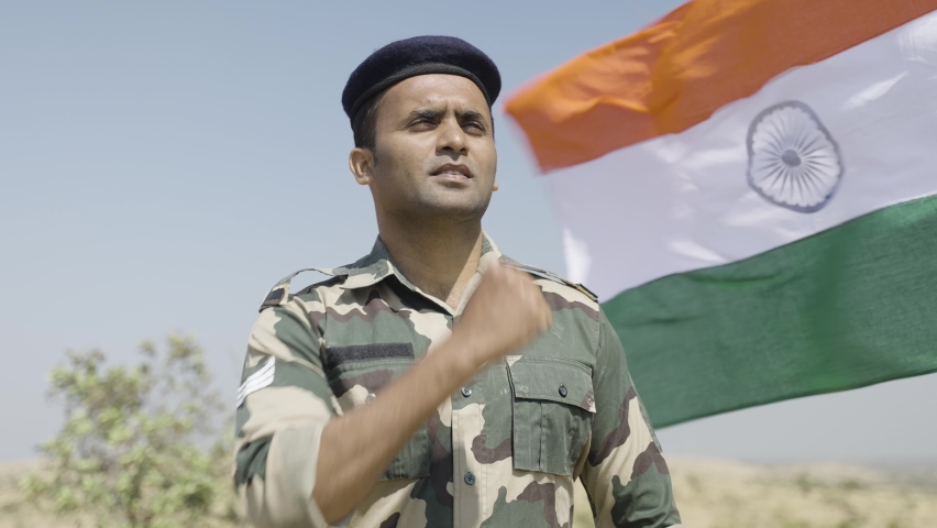 front view low angle shot of Proud Indian army soldier saluting while waving indian flag in background - concept of patriotic, nationalism, independence day celebration and honour Royalty-Free Stock Footage #1088120929