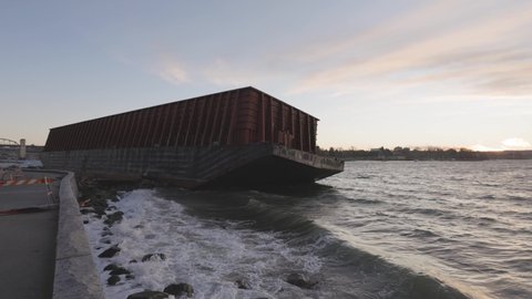 Barge container ship collided on a rocky coast during wind storm. Sunset Sky. Seawall, Downtown Vancouver, British Columbia, Canada. Slow Motion