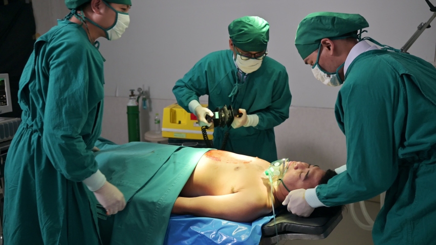 Team of doctor and assistant helping by AED defibrillation with accident injured patient unresponsive in emergency room Royalty-Free Stock Footage #1088125437