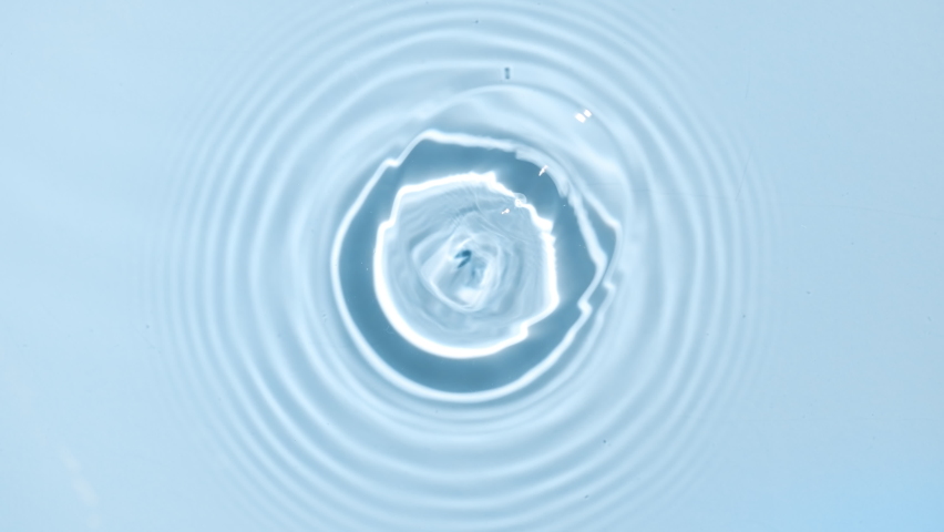 Water drop making water ripples on water surface on blue background | skin care background, moisturizing serum commercial