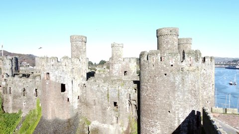 Medieval Conwy castle Welsh market town turrets aerial rising view above historical harbour