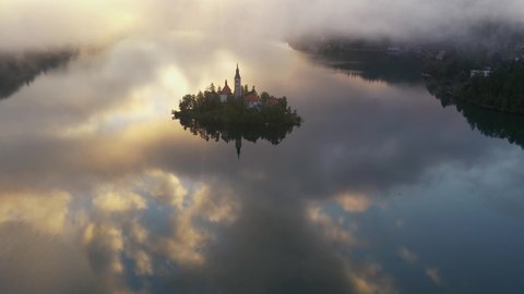Lake Bled on a beautiful autumn morning. Sunrise in the hills after a misty night.