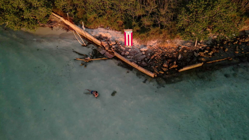 Backward Drone Puerto Rico flag video in golden hour beach.