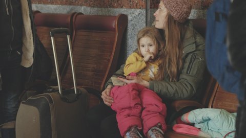Lviv, Ukraine - March 15, 2022: The humanitarian crisis in Europe caused by Russia's attack on Ukraine. Ukrainian refugees mother and daughter at the railway station. Woman calming her child