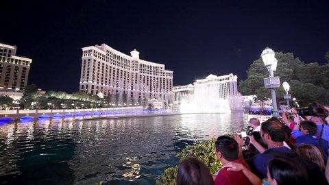 LAS VEGAS, NV - JUNE 30, 2018: Tourists enjoy Bellagio Hotel fountain lights show at night. Las Vegas is the world gambling capital.