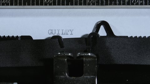 Typing the expression GUILTY with an old manual typewriter