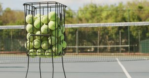 Video of basket with tennis balls on tennis court. professional tennis training, sport and competition concept.