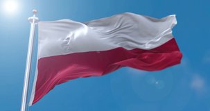 View of Polish flag flapping on flagpole with sky behind