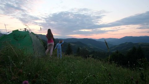 Girlfriend girls are photographed at sunset in the mountains. Photos for social networks