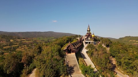 Phu Ruea , Loei , Thailand - 01 03 2022: Aerial footage towards the temple revealing an entrance and people going up and down the staircases, Wat Somdet Phu Ruea, Ming Mueang, Loei in Thailand.