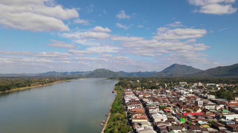 Aerial footage descending and revealing the Walking Street in Chiang Khan and the Mekong River plus Laos on the left, Loei in Thailand.