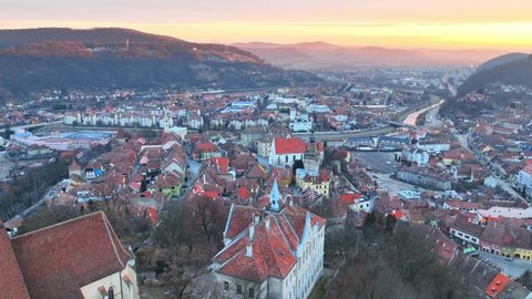 sunrise in historic medieval town of Sighisoara, aerial view of famous tourist destination in Romania, scenic unesco heritage site in Transylvania in winter. High quality 4k footage