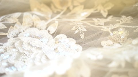 Close up pan of lace on wedding dress detail shot