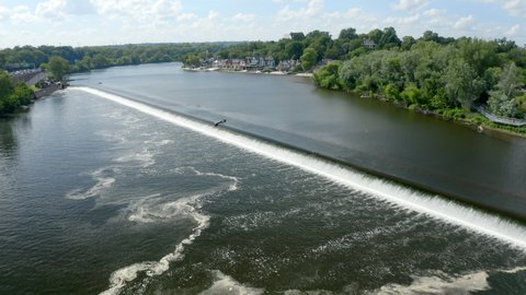 Aerial Shot of a Dam Along the Schuylkill River in Philadelphia with the Historic Boathouse Row in the Background