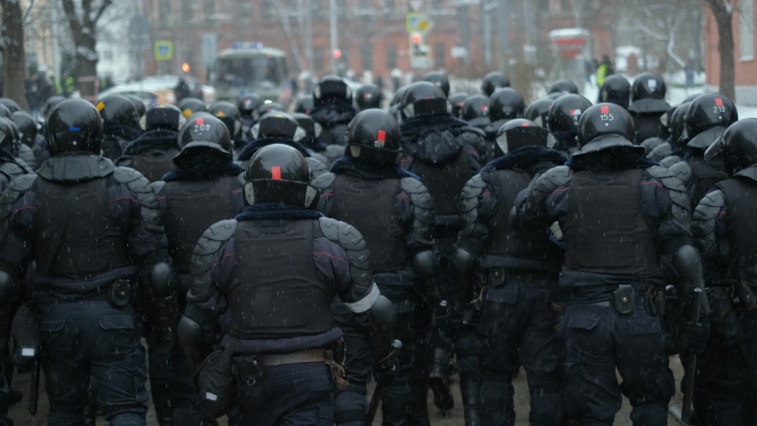 Political protests with riot police on streets of winter Moscow. Resistance strike, demonstration rally in Russia. Enforcers pushing activists. Walking, marching line of OMON police riot officers. Royalty-Free Stock Footage #1088152243