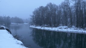 Beautiful winter landscape, snow falling on the river. Panning 4K
