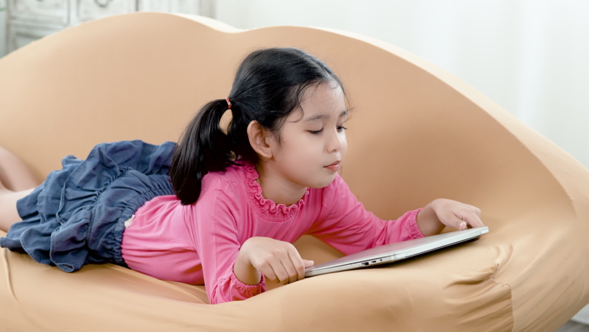 4K 50fps, Cute Asian little girl wearing a pink shirt and blue skirt, lazy to turn on the computer because she doesn
