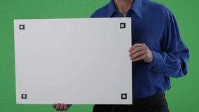 Businessman holding horizontal empty white placard showing copy space with tracking points on green screen chroma key background. - Powered by Shutterstock - Get 15% off with code: PIKWIZARD15