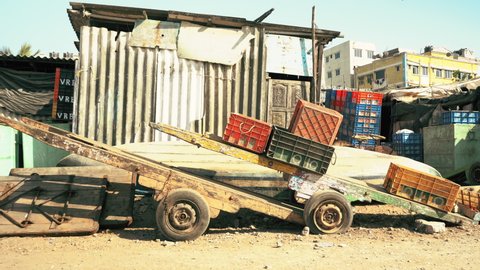 Wooden hand cart and plastic crates at junk yard, Mumbai, India, Circa 2022