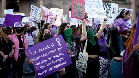 Monterrey, Mexico - March 8th 2022: Women in Mexico protesting against violence with signs and singing "we throw rapists penis into the blender"