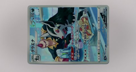 Hamburg, Germany - 03122022: video of the japanese character rare card Mightyena from the set Battle Region. Led light moves over pokemon trading card to show the shiny paper surface in 4k.