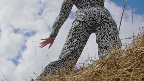 Close Up Sexy Brunette Woman sensually Dancing on top bale of hay. Back view. Happy Trendy Female